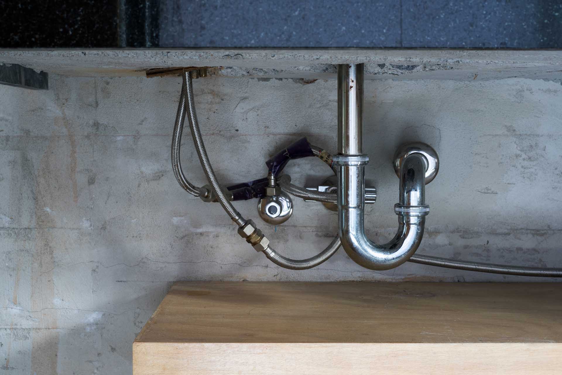 Bathroom stainless steel sink pipes, trap and drain on concrete wall.; Shutterstock ID 680252392; PO: 25pack; Job: 20180906; Client: tt; Other: aa
